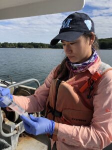 Woman looks at water sample on boat